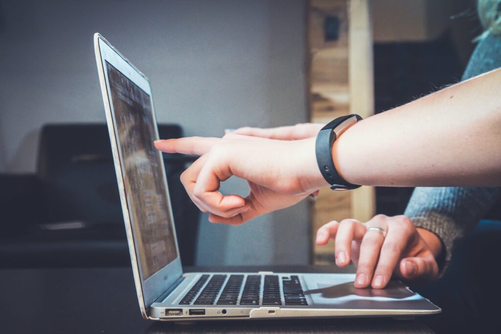 Eine Person zeigt die Problematik dem Kunden auf einen Laptop